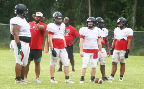 Fort White offensive coordinator Jonathan Dupree (second from left) talks to offensive lineman Caiden Campbell and the rest of his offensive line during Monday’s practice.