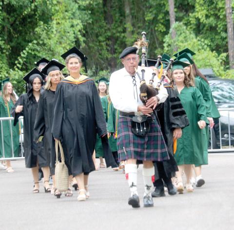 A First Coast Highlanders bagpipe player leads the procession of Florida Gateway College professors and graduation candidates into the gymnasium on Thursday evening for the school’s summer graduation ceremony. (TONY BRITT/Lake City Reporter)