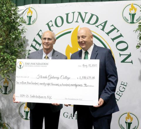Van Long (left), the Foundation For Florida Gateway College board chair, stands with Lawrence Barrett, Florida Gateway College President, holding a ceremonial check for $1.3 million, representing funds for scholarships and to support other programs at the college. (TONY BRITT/Lake City Reporter)