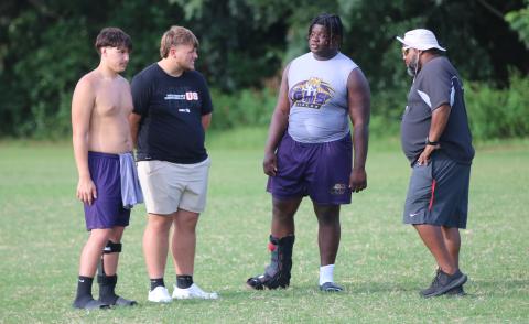 Columbia offensive lineman De’manuel Jones (right center) talks to offensive linemen Aiden Jenkins (left) and Zackery Grimes (left center) as well as running backs coach Quintin Callum during Monday’s practice. (JORDAN KROEGER/Lake City Reporter)