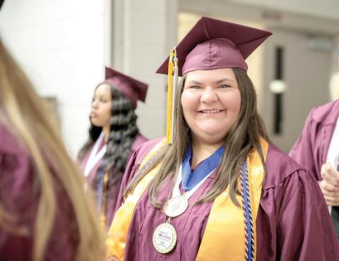 Standing among fellow expectant graduates at the NFC Spring 2025 Commencement Ceremony, Caroline Wynn smiles as she prepares to cross the stage and accept her diploma for an Associate in Arts Degree. (COURTESY)