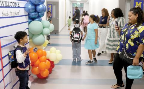 Logan Rivera (left), 5, poses in front of a back to school sign for Isabel Garcia, as he prepares to head to his first day of school. (TONY BRITT/Lake City Reporter)