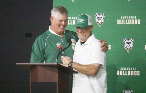 Bill Ragans (left) and Kyler Hall share a hug and a laugh during the Suwannee football 100-year celebration Friday night at the Suwannee Coliseum. (JAMIE WACHTER/Lake City Reporter)