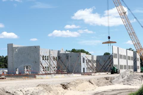 Construction crews continue progressing with the work at the new Eastside Elementary Schools with concrete walls for the first floor of the new building lifted into place this week. (TONY BRITT/Lake City Reporter)