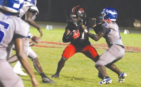 Fort White running back John’l Lawson tries to break away from a tackle Friday against Belleview. (MORGAN MCMULLEN/Lake City Reporter)