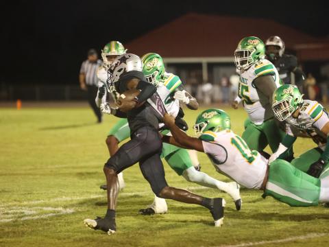 Madison County quarterback LJ Crumity pulls away from Suwannee linebacker Marco Rojas as De’aumann Jones closes in Friday night at Boot Hill. (PAUL BUCHANAN/Lake City Reporter)