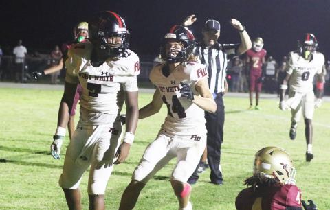 Fort White receiver Ashton Giddens (right) runs to celebrate with fellow receiver X’Zaevion Gibson after Gibson’s go-ahead 31-yard touchdown catch in Friday’s 41-40 win over North Marion. (MORGAN MCMULLEN/Lake City Reporter)