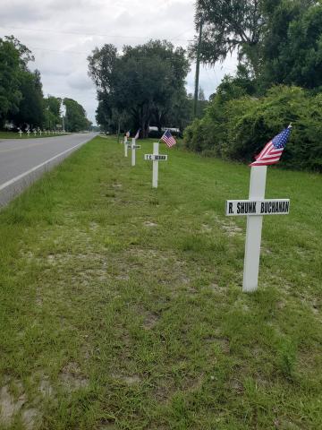 Crosses and flags line County Road 53 in Day several years ago. The crosses in honor of veterans will go up Monday there and on Tuesday by the Masonic Lodge in Mayo. (COURTESY)