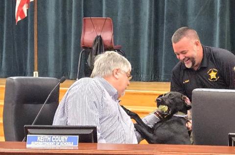 Columbia County Schools Superintendent Keith Couey (left) greets Jade as Columbia County Sheriff’s Deputy Kevin Bailey introduces her to the school board. (COURTESY COLUMBIA COUNTY SHERIFF'S OFFICE)