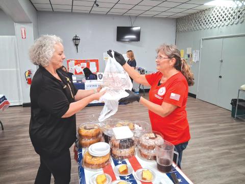 Columbia County Sheriff’s Office Maj. Katina Dicks (from left), gets a bag of to-go plates for CCSO staff from Lisa Toliver, an American Legion Auxiliary member. (TONY BRITT/Lake City Reporter)