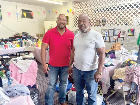 Kevin Parnell (left), Columbia County District 1 Commissioner, stands with Lester McKellum, director of the Greater Lake City Community Development Corporation, in the midst of contributions that were donated to Cedar Park Apartment complex fire victims. (COURTESY)