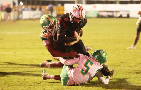 Baker County quarterback Hudson Register runs through Suwannee defenders Marco Rojas (15) and Kamari Lovett for the game-winning score in overtime Friday night. (PAUL BUCHANAN/Lake City Reporter)