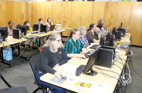 Columbia County Public Library Director Katrina Evans (left) and other library staff members sit through training in the main branch library as the library prepares to launch a new website and system. (TONY BRITT/Lake City Reporter)