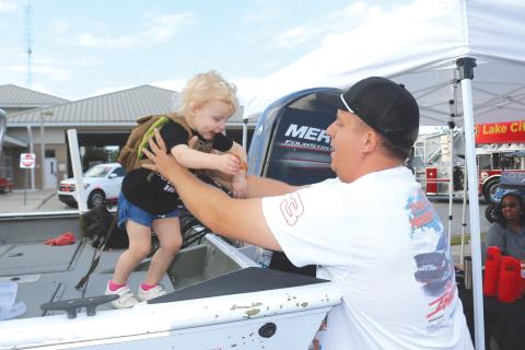 Landry Levai (from left), 2, gets a lift from Blaise Levai after walking on the Columbia County Sheriff’s Office Search and Rescue Boat during the National Night Out event on Tuesday evening. (TONY BRITT/Lake City Reporter)