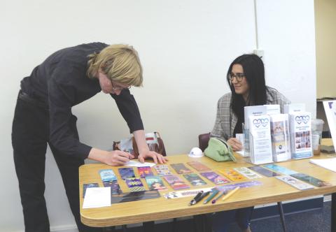 Coal Williams (left) completes information for Samantha Waldron, an employee at Another Way, during the inaugural Career Cafe. (TONY BRITT/Lake City Reporter)