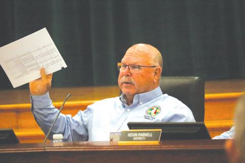 Columbia County Commissioner Rocky Ford holds up a document during the discussion about whether to renew the contract with WastePro on solid waste collection or go back out to bid. (JAMIE WACHTER/Lake City Reporter)