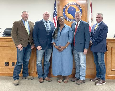 Gigi Gwinn, the widow of Donnell Gwinn, is pictured with Suwannee County Commissioners Leo Mobley (from left), Don Hale, Chairman Travis Land and Franklin White after they passed a proclamation in her late husband’s honor. The county also plans to name a new building at the fairgrounds after Donnell Gwinn. (JAMIE WACHTER/Lake City Reporter)