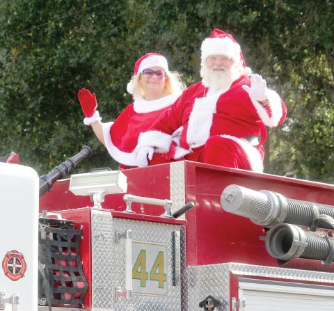 Santa and Mrs. Claus wave from a Columbia County Fire Rescue truck during last year’s Fort White Christmas parade. (FILE)
