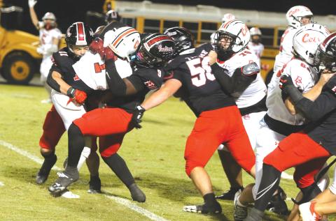Fort White defensive end Josiah Harmon (9) and linebacker Teagan Bell combine for a tackle on Baker County’s Delynno Ruise in Friday’s 19-7 win. (MORGAN MCMULLEN/Lake City Reporter)