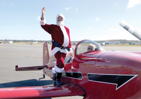 Santa Claus waves after landing in an airplane at the Lake City Gateway Airport for the inaugural Pilots With Presents Fly-In in 2023. (FILE)