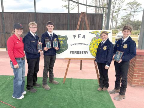 Lafayette Middle FFA won its fourth state forestry title in five years Nov. 6 at the Florida Forest Festival Grounds in Perry. State champion team members were Miles Jackson, Brock King, Alex Stewart at Madison Ward. They are pictured with FFA Advisor Tori Lyons. (COURTESY)