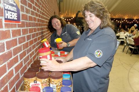 Paulette Tomlinson (right) and Heather Futch with the Columbia County UF/IFAS Extension Office sort through jars of unopened peanut butter that were donated for the 2025 Peanut Butter Challenge at the Farm to Table event earlier this month. (TONY BRITT/Lake City Reporter)