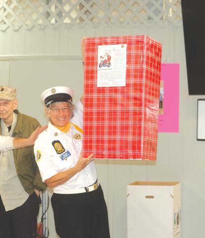Elaine Lagasse, a member of the American Legion Post 57 Honor Guard, displays a collection box for the upcoming charity ride that scheduled to take place on Saturday. (TONY BRITT/Lake City Reporter)