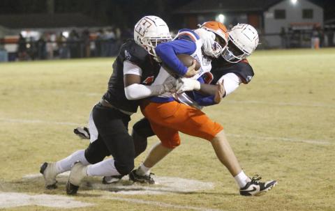 Branford quarterback Trent Land gets his facemask pulled by a Hawthorne defender during Friday night’s Class Rural quarterfinal. (JAMIE WACHTER/Lake City Reporter)