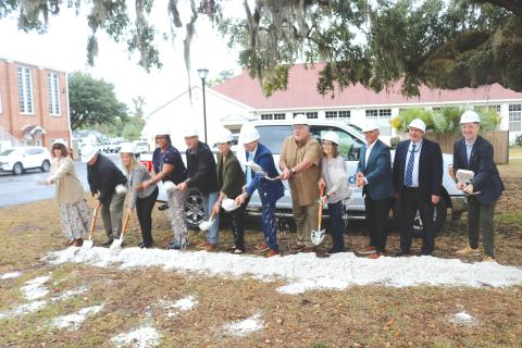 Tossing dirt to celebrate the construction of a new private fiber network for the school district were: Cindy Forsyth (from left), Jay Duval, Denise Weybrew, Hope Jernigan, Todd Widergren, Dana Brady-Giddens, Patrick Mitchell, Keith Couey, Cherry Hill, Jesus Pena, Billy Merchant and Oliver Landow. (TONY BRITT/Lake City Reporter)