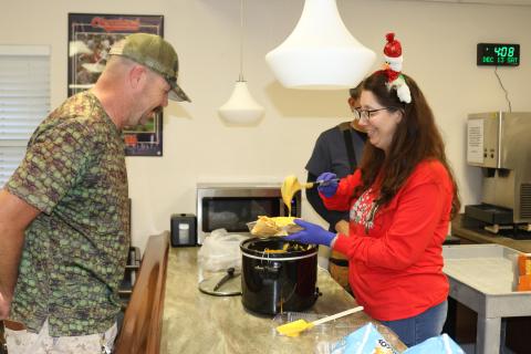 Matthew Isaacs (left), a U.S. Coast Guard veteran, gets a bowl of nachos and cheese from Karen Kraszewski, a recreational aide on Saturday at the Robert H. Jenkins Jr. Domiciliary where veterans watched the Army-Navy football game. (TONY BRITT/Lake City Reporter)