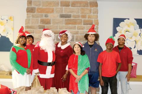 Tammy Harris (from left), Kathy Dix, Bo Beauchemin, Befaithful Coker, Judith McClure, Malachi Thompson, Michael Coker and Victoria Coker, members of It’s About My Efforts, which is part of the Our Community Cares Coalition, visited assisted living facilities on Sunday giving senior citizens goodie bags and other items. (TONY BRITT/Lake City Reporter)