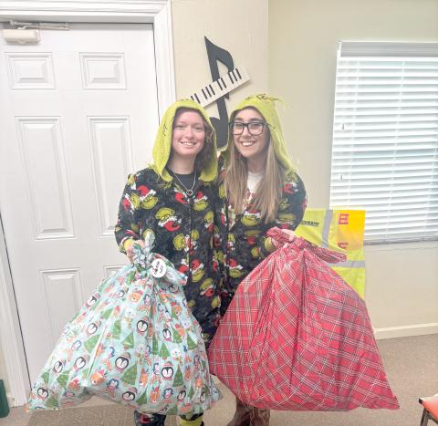 Taylor and Kayli McCathern hold bags of presents that God’s Hidden Angels collected for underprivileged children in Suwannee County. (COURTESY)