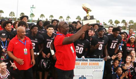 Fort White coach Demetric Jackson hoists the Rural FIT championship trophy following the Indians’ 32-29 win over Port St. Joe on Friday. (MORGAN MCMULLEN/Lake City Reporter)