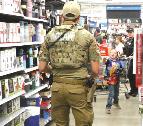 Kenneth Hammett, 7, tries out a new ball and glove in the aisles during last week’s Shop with a Hero event at the Live Oak Walmart. (MORGAN MCMULLEN/Lake City Reporter)