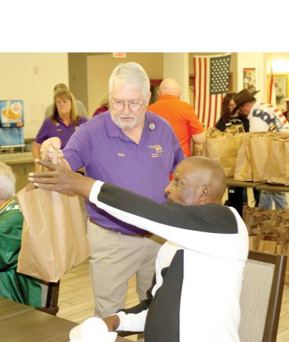 Florida Elks State President Mike Chandler delivers a goodie bag to a veteran at the Robert H. Jenkins VA Domiciliary on Saturday. Chandler was visiting the district Saturday and got to help Lake City Elks Lodge #893 members on the project. (TONY BRITT/Lake City Reporter)