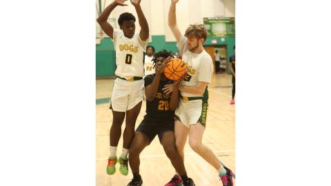 Columbia center Terrance Tolbert (20) looks for an opening to shoot while defended by Suwannee guard Travon Fead (0) and forward Bryson Parlato on Friday. (PAUL BUCHANAN/Lake City Reporter)