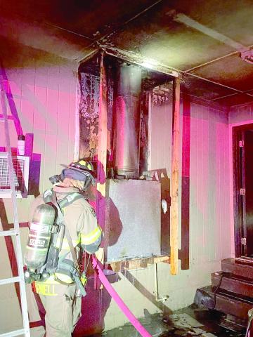 A Lake City firefighter helps extinguish a fire Tuesday night in a house off Siesta Place. The fire, which was found around the chimney for the house’s fireplace, was quickly extinguished and the home was still habitable. (COURTESY LAKE CITY FIRE DEPARTMENT)