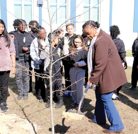 Niblack Elementary School Principal Makeba Murphy adds dirt to the hole where a Shumard Oak tree was planted at the school on Friday for Florida Arbor Day. The tree was donated by the Lake City Garden Club. (TONY BRITT/Lake City Reporter)