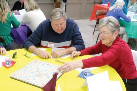 Ferne Mann (right) tosses the bag of letters to other Scrabble players while her tournament partner Mark Kirby looks on during last year’s Lake City Garden Club’s Scrabble Tournament at First Presbyterian Church. (FILE)
