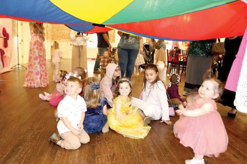 Youngsters attending the Baby Prom at the Blanche Hotel play under a parachute of cloth. (TONY BRITT/Lake City Reporter)