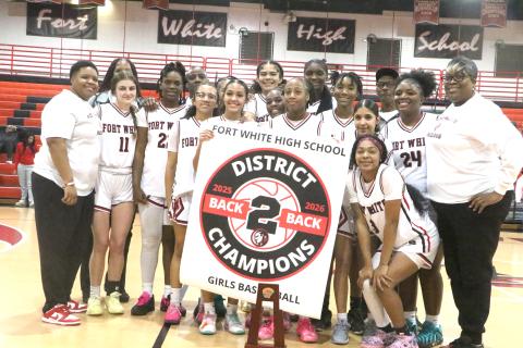 Fort White's girls basketball team displays its banner and trophy after Friday's 64-30 win over Taylor County in the District 6-R championship. (MORGAN MCMULLEN/Lake City Reporter)