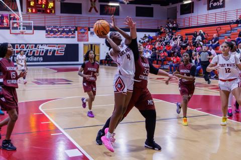 Fort White guard Erickah Roberson fights through a Madison County defender to make the shot during the Region 3-R semifinals on Feb. 13. (JACK HOWDESHELL/Lake City Reporter)