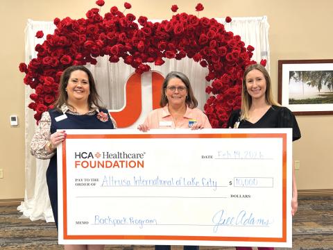 Ginny McCall (left) and Lindsey Covington (right) present a $10,000 check from HCA Florida Lake City Hospital to Sandy Thompson (center) for Altrusa International of Lake City in support of its backpack program, which provides food to local students in need. (COURTESY)