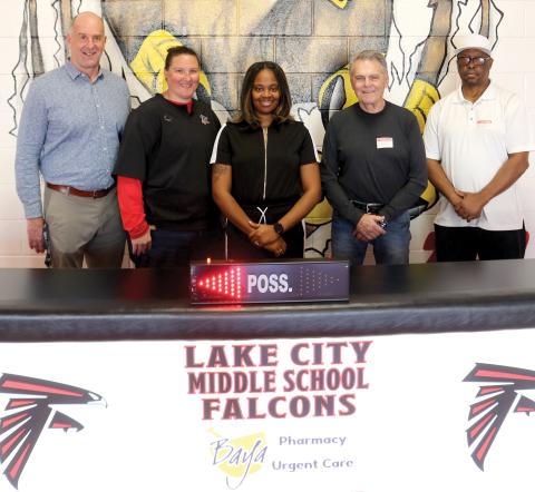 Lake City Middle School officials Dennis Dotson, Brianna Collier and basketball coach Shaniqua Henry, stand with Carl Allison and Wayne Jernigan showing off a new scorer’s table for the school which arrived Tuesday morning. (TONY BRITT/Lake City Reporter)