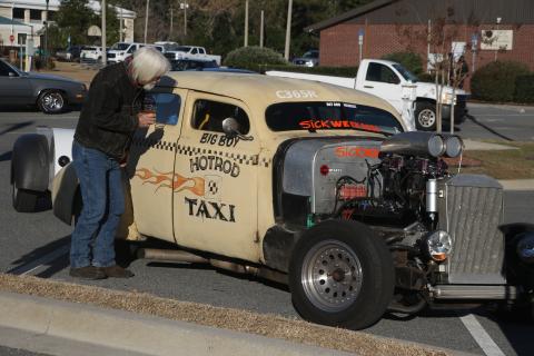 Bob Hubbard checks out the interior of the Hotrod Taxi Monday afternoon as Sick Week participants and observers flocked to Lake City for a pit stop. (MORGAN MCMULLEN/Lake City Reporter)