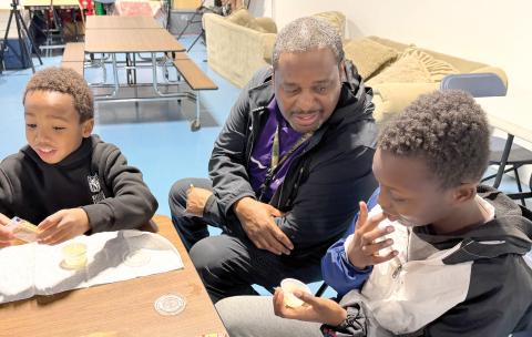 Niblack Elementary physical education coach James Williamson coaxes students Augest and Kingston to try the results of their efforts in making butter. (COURTESY UF/IFAS EXTENSION COLUMBIA COUNTY)
