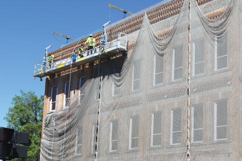 Innovative Masonry Restoration workers get set on tearing down the netting surrounding Lake City Hall. The netting will not make a return once it’s down. (TONY BRITT/Lake City Reporter)
