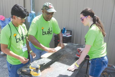 Angel Gomez, a Columbia High School student, gets tips on sanding wood from Monty Ashby, as Gomez and Kiley Morrison sand wood to make beds for the Sleep in Heavenly Peace program during last year’s Build My Future event. (FILE)