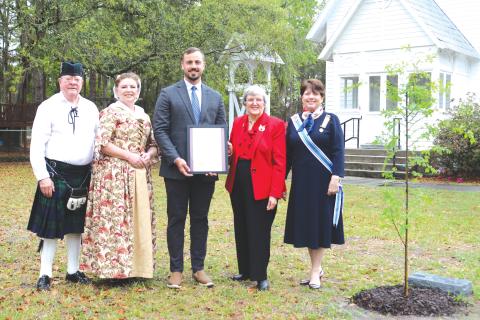 David Chandler (from left), Sons of the American Revolution, Scarlet Frisina, Lake City Mayor Noah Walker, Jane McClelland, Daughters of the American Revolution, and Kay Yarbrough, Honorary State Regent of the Florida State Society Daughters of the American Revolution, pose next to the new Liberty Tree planted at St. James Episcopal Church in honor America’s 250th Anniversary on Wednesday for the Edward Rutledge Chapter, Daughters of the American Revolution. (TONY BRITT/Lake City Reporter)