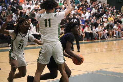 Columbia center Terrance Tolbert tries to find an opening to shoot while defended by Fleming Island guard Ayden Greenidge (21) and center Jalil Hill (11) during the Region 1-5A finals on Saturday. (JORDAN KROEGER/Lake City Reporter)